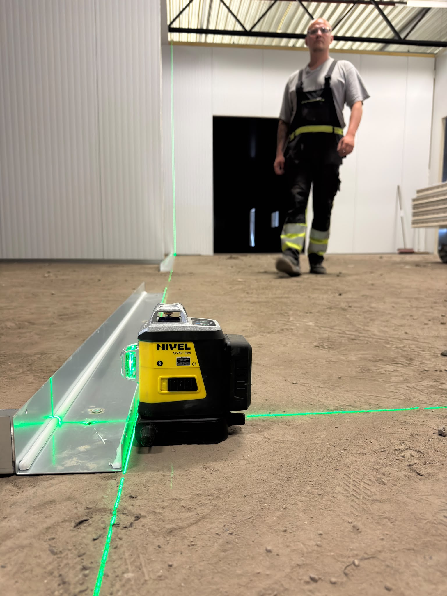 De montagelijn van de wand uitzetten met een laser.